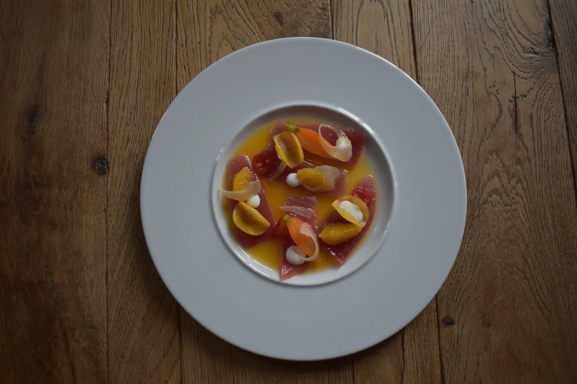 Rauwe tonijn met ham, mandarijnpartjes en zilveruitjes in een oranje citrusdressing