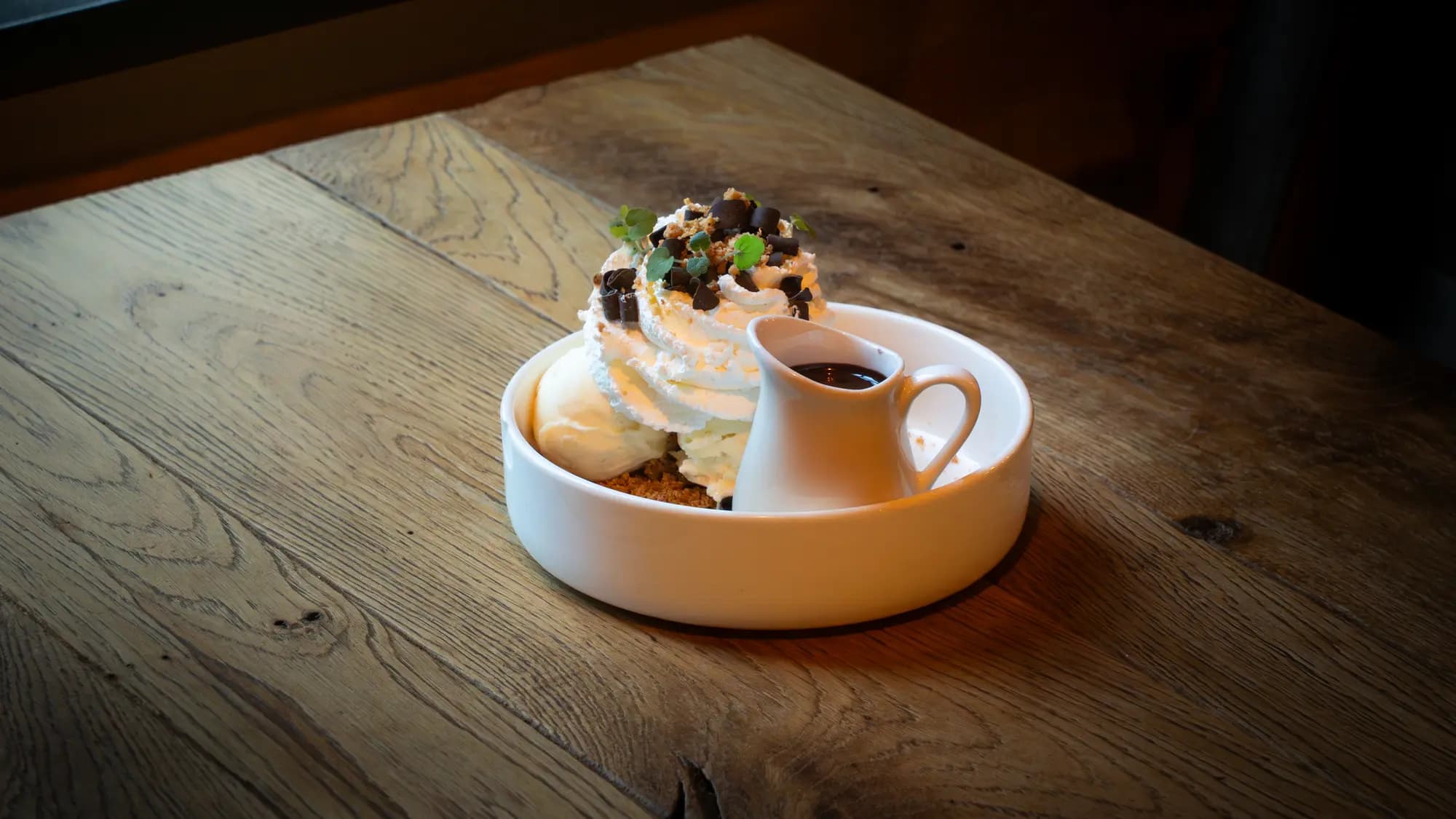 Dame blanche met slagroom, ijs en chocoladeschaafsel, met een kannetje warme chocoladesaus