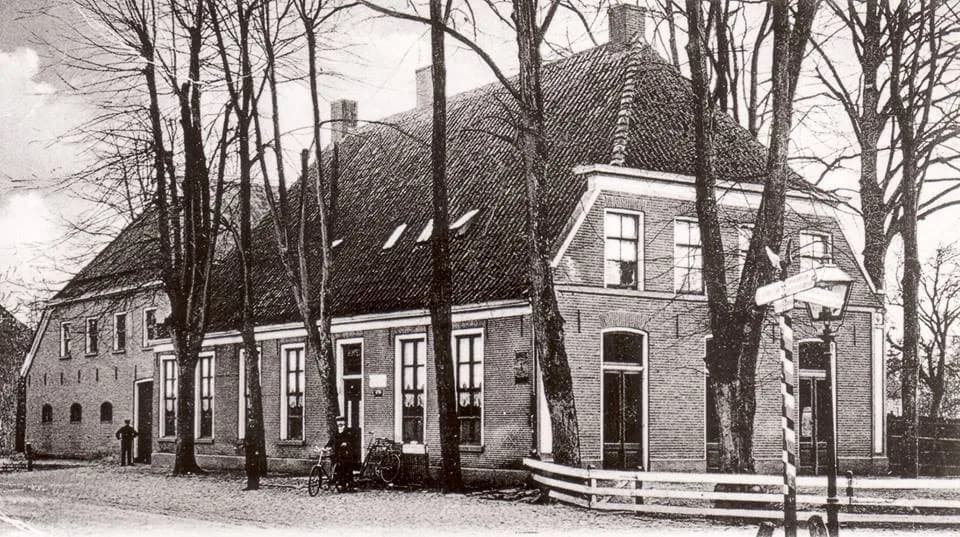 Zwart-witfoto van Hotel de Boer aan de Hoofdstraat 23 in Dalen in de jaren '20, met kasseienstraat en fietsen voor de deur